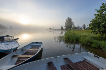 Naklejka premium Early morning. Fog on the river. Beautiful sunrise in the summer by the river. boats at the pier.
