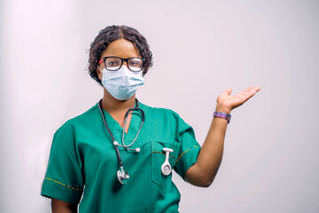 image of african health official, with face mask, stethoscope around the neck and a raised arm