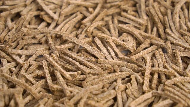 Cereal wheat fiber sticks. Close up. Falling onto a heap in slow motion