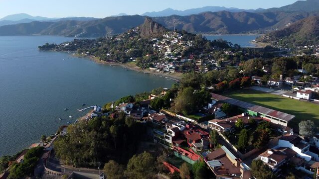 Overflight over the magical town Valle de Bravo in Mexico and a lake with mountains in the background. Sped up x2