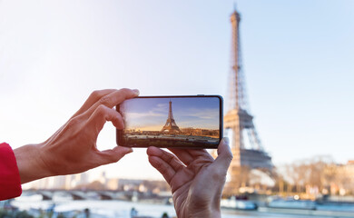 Naklejka premium Selective focus of man hand with he is using smartphone take photo at View on Eiffel Tower, Paris, France