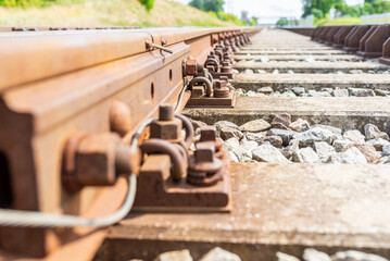 Railway track details closeup photo with selective focus.Close-up view of railway bolts.Summer day details of railway