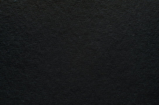 Rough texture of black paper with fibers, macro photography. Close-up paper background top view