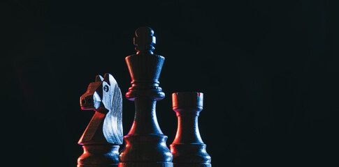 Chess pieces on a dark background © stokkete