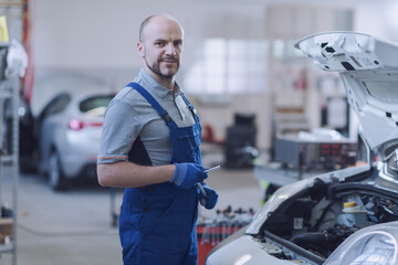 Confident mechanic posing in the garage