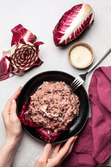 Cooking italian risotto with red radicchio, pancetta and taleggio cheese.  Ingredients on the...