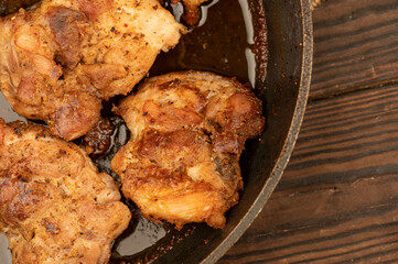 Fried pieces of meat in a frying pan, close-up, selective focus.
