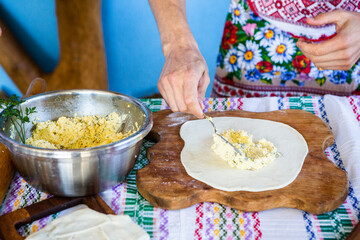 image with the hands of a lady cooking traditional Romanian fried pies with cheese in traditional...