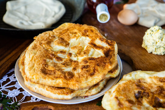 image with the hands of a lady cooking traditional Romanian fried pies with cheese in traditional clothes.