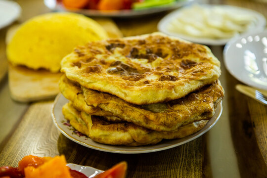 image with the hands of a lady cooking traditional Romanian fried pies with cheese in traditional clothes.