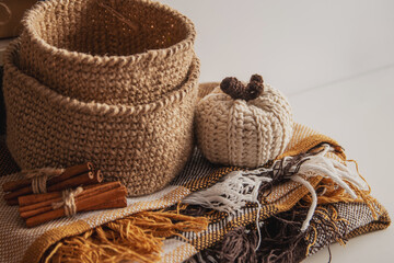 Concept cozy autumn brown colors. Jute basket crocheted, knitted poking, cinnamon, blanket.