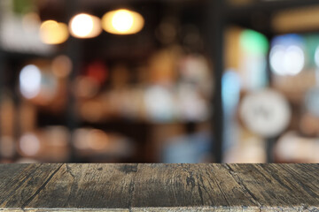 Empty dark wooden table in front of abstract blurred bokeh background of restaurant . can be used for display or montage your products.Mock up for space.