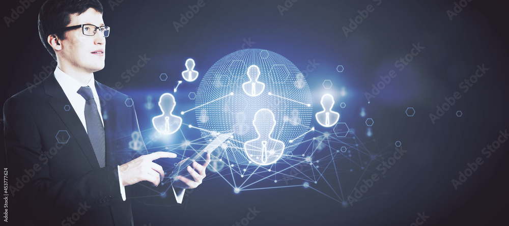 Aufkleber Handsome businessman hand using smartphone with glowing globe interface with people icons on dark background. Social networking, communication and recruiting concept.