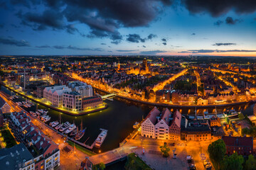 Fototapeta premium Amazing architecture of the main city in Gdansk at dusk, Poland. Aerial view of the historical Port Crane at the Motlawa river