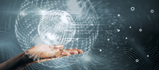 Male hand holding creative glowing polygonal globe hud interface on blue background. Network and digital communication concept.