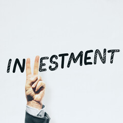 Businessman hand with peace sign gesture replacing letter V in investment word on white background with mock up place. Finance and trade concept.