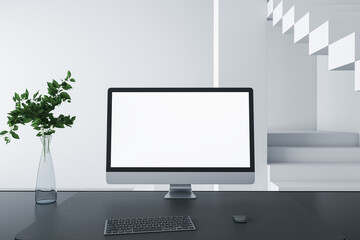 Close up of designer desktop with empty white computer screen frame, decorative items and modern interior in the background. Mock up, 3D Rendering.