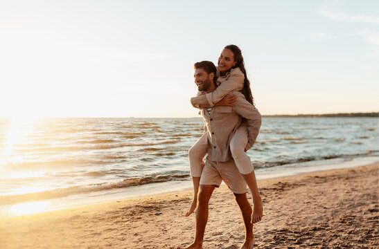 leisure and people concept - happy couple having fun on summer beach