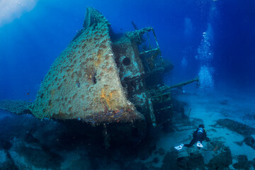 A scuba diver sxplores a sunken shipwreck in the mediterranean sea, Greece