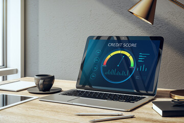 Close up of creative office desktop with credit score page on laptop screen, coffee cup, supplies and daylight. Workplace, business loan and debt rating concept. 3D Rendering.