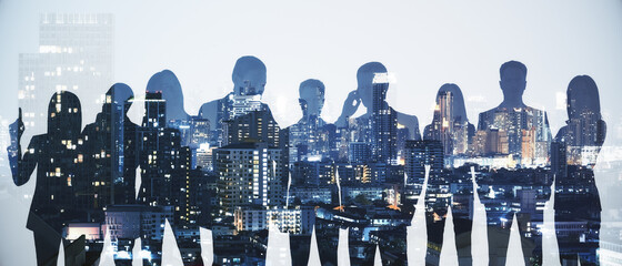 Wide image of business people silhouettes standing on abstract night city background. Teamwork and...