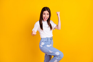 Fototapeta na wymiar Photo of young happy excited crazy cheerful smiling woman raise fists in victory success isolated on yellow color background