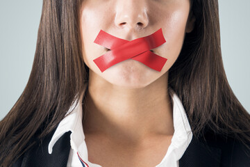 Close up of taped caucasian businesswoman mouth. Silence and speech censorship concept.