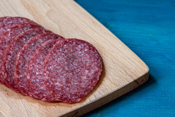 Fresh raw smoked sausage slices on a cutting board.