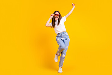 Fototapeta na wymiar Full body photo of young excited girl happy positive smile hipster hands touch sunglass isolated over yellow color background