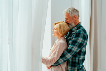 Retired husband and wife hug each other at home