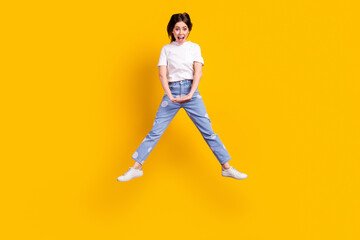 Fototapeta na wymiar Full length photo of young girl happy positive smile have fun jump up isolated over yellow color background