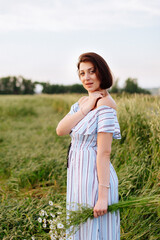 Beautiful young woman in summer in a wheat field