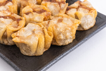 Fried shumai or Chinese dumplings on Black Plate, Food or Cooking Background, Nobody