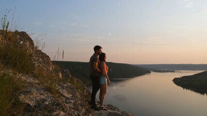 Obraz premium The romantic couple standing on rocky mountain top above the river