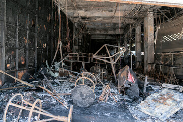 a burnt-out cafe in Thailand, insurance of premises against fire. Burnt furniture and chairs. an...