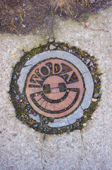 Vertical shot of a rusty manhole cover with the Polish word woda for water © Mirco Vacca/Wirestock