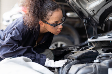 Female mechanic working at the garage. Professional female car mechanic examining, repair and...