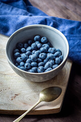cuenco con arándanos sobre tabla de madera