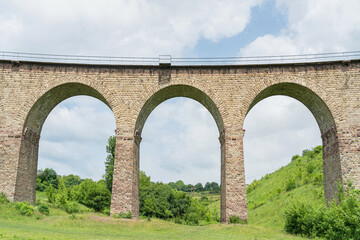 Fototapeta premium Large arches of the ancient railway bridge-viaduct. Bottom view