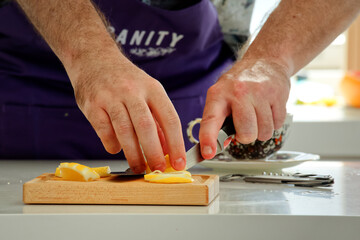 View of male's hand chopping up lemons for making cocktails
