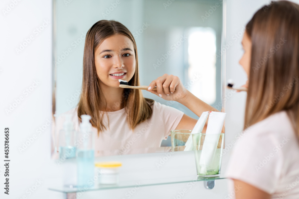 Canvas Prints dental care, hygiene and people concept - happy smiling teenage girl with toothbrush brushing teeth at bathroom