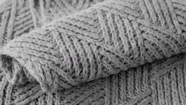 Handmade knitted grey wool shawl with geometric modern design. Abstract background pattern.