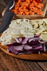 Onions and other vegetables on a chopping board