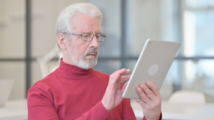 Portrait of Old Man using Digital Tablet