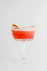 Fruit citrus cocktail in a glass over white background. Delicious alcoholic beverage, sweet drink in a glass.