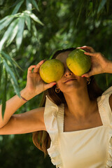 Woman with mango under tree, vegetarian