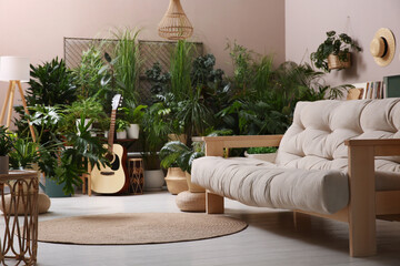 Living room interior with stylish furniture and different houseplants