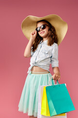 cute little caucasian child girl holds shopping bags