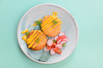 Grilled burgers with sauce and vegetable radish salad on a plate over mint green background. Healthy eating.