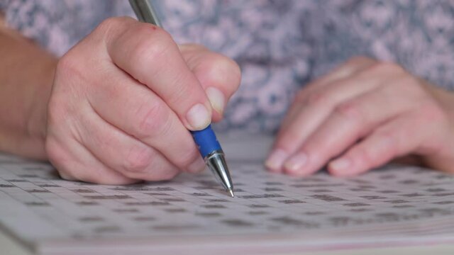 Brain and memory training. Elderly woman solving crosswords